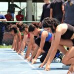 Alunas em posição de início em uma das modalidades do atletismo.